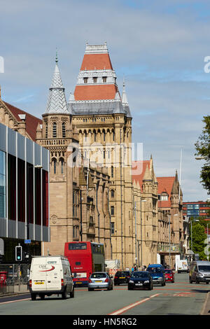 Sonnigen Tag große Wahrzeichen gotische äußere Gebäudeteil des Manchester University Campus, Whitworth Halle im Hauptkorridor A34 Oxford Road bus Stockfoto