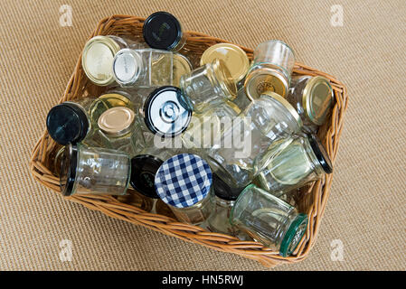 Leere Glasgefäße mit Deckeln in einem gewaschenen Korb, der zur Wiederverwendung, Lagerung oder zum Recycling bereit ist. Stockfoto