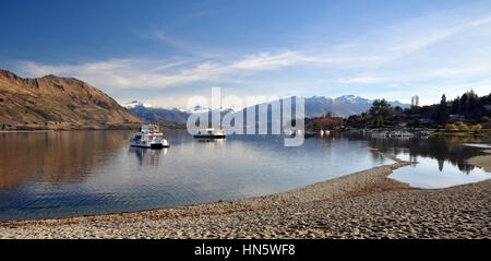 Lake Wanaka und Boote mit den südlichen Alpen im Hintergrund. Central Otago, Neuseeland. Beachten Sie im Vordergrund wie tief der Seepegel liegt nach einem Stockfoto