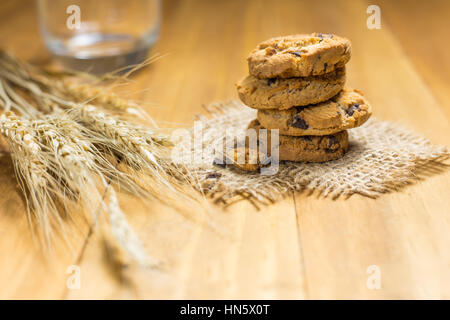 Schokoladen-Plätzchen auf meschotschek Tuch auf Holz. Schokoladenkekse erschossen auf einem braunen Tuch. Stockfoto