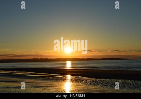 Sonnenuntergang über Anglesey aus Llanfairfechan Stockfoto