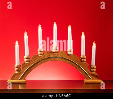 Weihnachten-Holz-Kerze-Halter mit Glühbirnen auf rotem Hintergrund, Beleuchtung und Dekoration für die Adventszeit Stockfoto