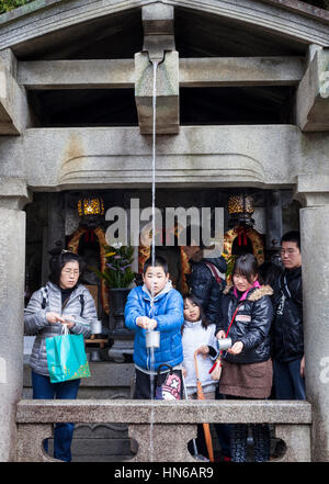 Kyoto, Japan - 24. März 2012: Menschen sammeln von Wasser aus dem Otowa-keine-Taki Wasserfall in Kiyomizu-Tempel in Kyoto. Besucher trinken das Wasser, das ist Stockfoto