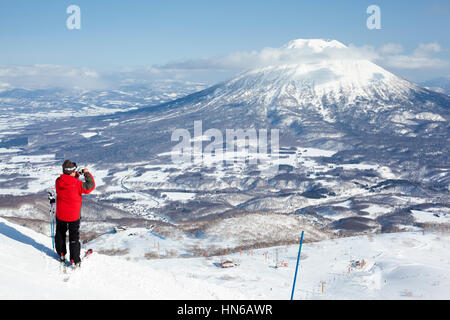 Niseko, Japan - 4. März 2012: Ein Skifahrer nimmt ein Foto des Mount Yotei von oben auf den Skipisten auf Niseko Annupuri Berg in Niseko, Electrizittswerken Stockfoto