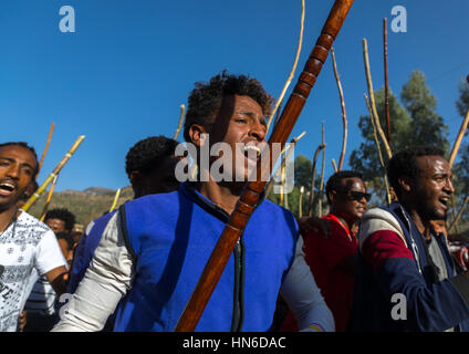 Äthiopischen jungen Männer tanzen und singen auf der Straße mit Stöcken während Timkat Epiphanie Festival, Amhara Region, Lalibela, Äthiopien Stockfoto