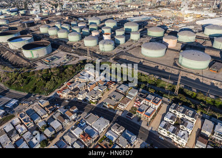 Los Angeles County, Kalifornien, USA - 17. Dezember 2016: Mittelklasse-Häuser unter großen Öl-Raffinerie-Tanks in Südkalifornien. Stockfoto