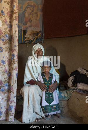 Porträt einer äthiopischen Mönch-Frau mit einem verwaisten Mädchen in einem Haus, Amhara Region, Lalibela, Äthiopien Stockfoto