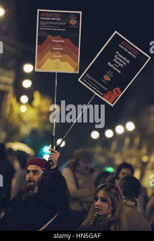 Bukarest, Rumänien - 6. Oktober 2013: Junger Mann hält zwei Protest Zeichen während der Großkundgebung gegen gold Cyanid Extraktion in Rosia Montana Stockfoto