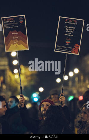 Bukarest, Rumänien - 6. Oktober 2013: Junger Mann hält zwei Protest Zeichen während der Großkundgebung gegen gold Cyanid Extraktion in Rosia Montana Stockfoto