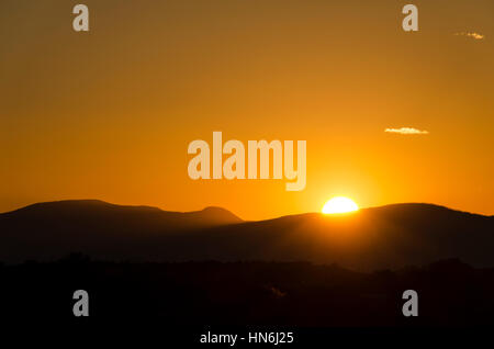 Ein buntes Sonnenuntergang in Santa Fe, New Mexico mit einer Sonne versteckt sich hinter Bergen. Stockfoto
