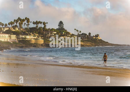 San Diego, USA - 14. Oktober 2015: Mann stand im Ozean an der Küste von La Jolla von Windansea Beach in San Diego, Kalifornien mit Häusern auf Felsen. Stockfoto