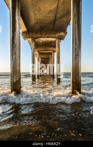 Symmetrisch unter Scripps-Pier mit Wellen während des Sonnenuntergangs in La Jolla, San Diego, Kalifornien gedreht Stockfoto