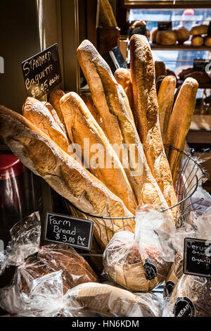 Baguettes im morgendlichen Sonnenlicht von einer Fensterbank in einer Bäckerei mit anderen Brotsorten Stockfoto