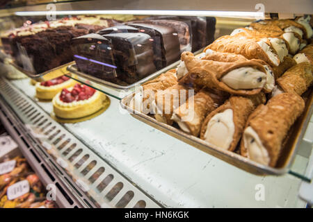 Cannoli und Scheiben Kuchen Dessert Display hinter Glas in einem Geschäft Stockfoto