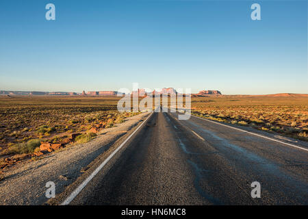 Blick auf Monument Valley Schluchten bei Sonnenaufgang mit Straße in Arizona Stockfoto