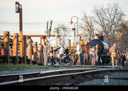 Sacramento, USA - Februar 20, 2016: Menschen zu Fuß auf Eisenbahnschienen während des Sonnenuntergangs in Capitol City von Kalifornien Stockfoto