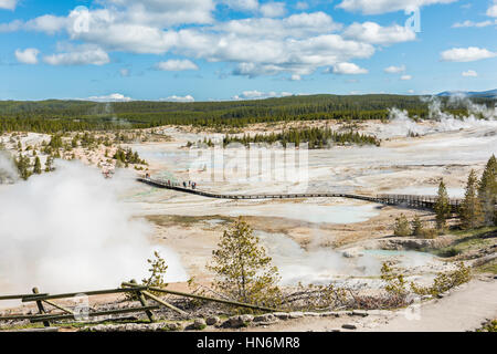 Yellowstone-Nationalpark, USA - 17. Mai 2016: Luftaufnahme des Menschen zu Fuß auf der Promenade von Norris Geyser Basin durch blaue heiße Quellen und Dampf Dampf Stockfoto