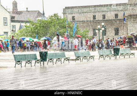 Quebec Stadt, Kanada - 27. Juli 2014: Menschenmenge Sonnenschirme herausnehmen und bei starkem Regen zu Fuß am Boardwalk Straße in der Nähe von Chateau Frontenac. Stockfoto