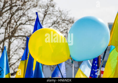 Zwei ukrainische Flagge farbige Luftballons in gelb und Blau am Protest mit Flaggen Stockfoto