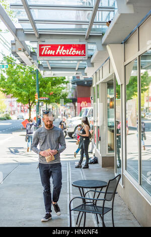 Vancouver, Kanada - 19. April 2016: Man walking von Tim Hortons Restaurant mit Essen in der Innenstadt von Stockfoto