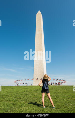 Washington D.C., USA - 27. August 2016: Zeile der amerikanischen Flagge durch das Denkmal auf der national Mall mit Frau auf der Suche Stockfoto