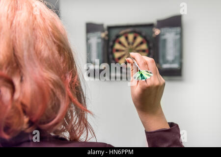 Nahaufnahme des Mädchens Kopf und Hand wirft einen dart Stockfoto