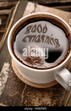 Tasse Kaffee und alte Buch auf hölzernen Hintergrund mit guten Morgen Inschrift Stockfoto