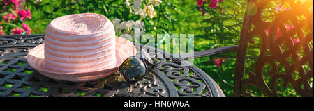 Hut und Sonnenbrille auf Tisch Stockfoto