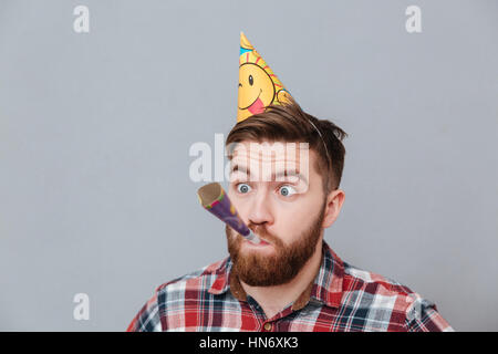 Foto von Geburtstag junge bärtige Mann steht auf grauem Hintergrund. Stockfoto