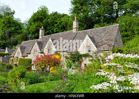 Traditionelle englische Kalkstein Hütten mit bunten, blühenden Sommergärten im Dorf Cotswolds, Gloucestershire Stockfoto