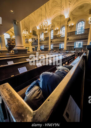 Obdachloser schlafen in Kirchenbänken der St. Martin-in-the-Fields, englische anglikanische Kirche an der Nordost-Ecke des Trafalgar Square in der Stadt Westm Stockfoto