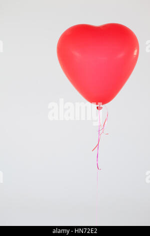 Herzförmige rote Ballon vor weißem Hintergrund Stockfoto