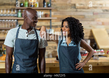 Lächelnd, Kellner und Kellnerin gegen Zähler in CafÃƒÂ © Stockfoto