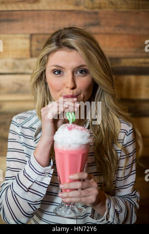Porträt der Frau trinken Milchshake mit einem Strohhalm im café Stockfoto