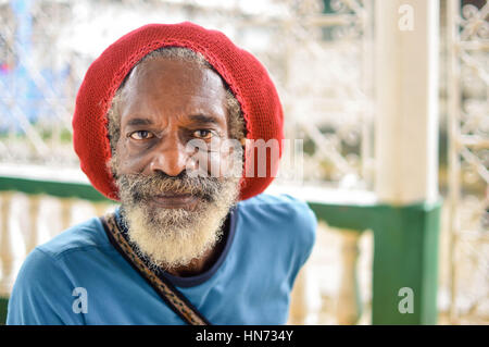 Bluefields, Nicaragua - Juli 15, 2015: Ältere rasta Mann trägt eine rote rasta Hut, die versteckt seine langen grauen Dreadlocks am 15. Juli 2015 in Dublin, n Stockfoto