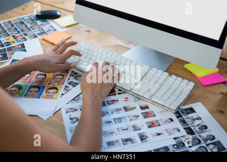 Frau, die Eingabe über Tastatur am Schreibtisch im Büro Stockfoto