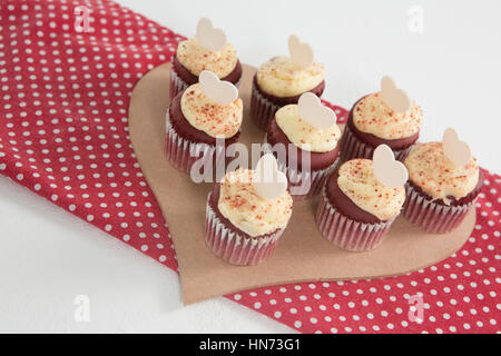 Cup Cakes in Herz-Form-Papier vor weißem Hintergrund Stockfoto