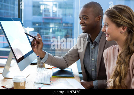 Grafik-Designer arbeiten mit Kollegen im Büro am Schreibtisch Stockfoto