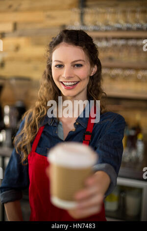 Porträt von lächelnden Kellnerin serviert eine Tasse in CafÃƒÂ © Stockfoto