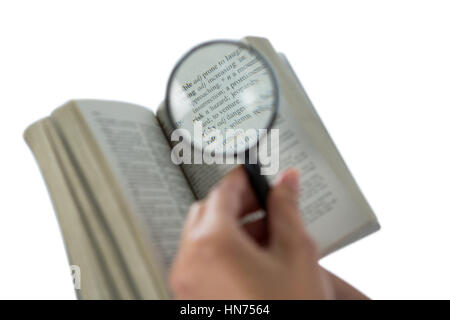 Nahaufnahme der Geschäftsfrau lesen ein Wörterbuch mit Lupe Stockfoto