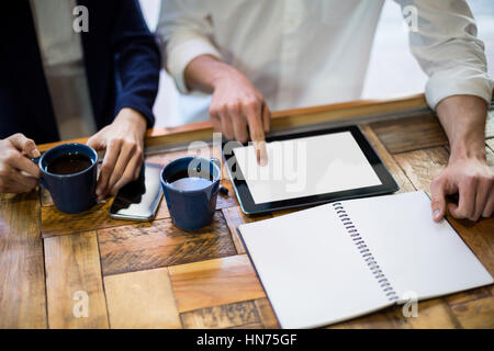 Mittelteil der Geschäftsleute, die mit digital-Tablette am Schalter im CafÃƒÂ © Stockfoto