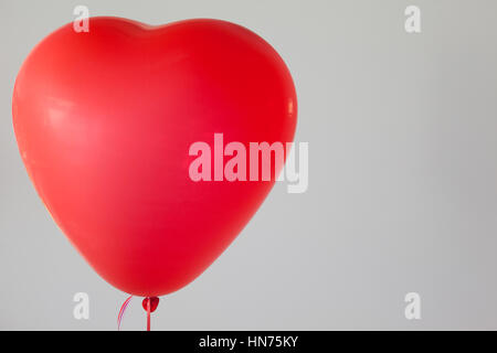 Herzförmige rote Ballon vor weißem Hintergrund Stockfoto