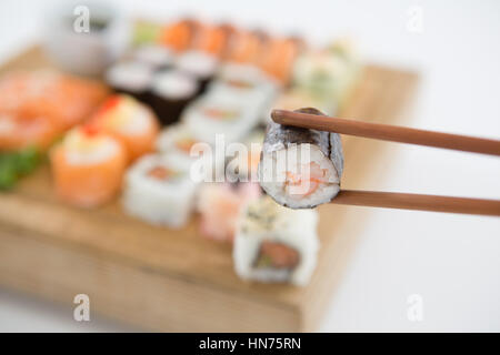 Nahaufnahme von Maki Sushi in hölzernen Stäbchen statt Stockfoto
