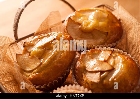 drei Apfel-Muffins in einem Weidenkorb Stockfoto