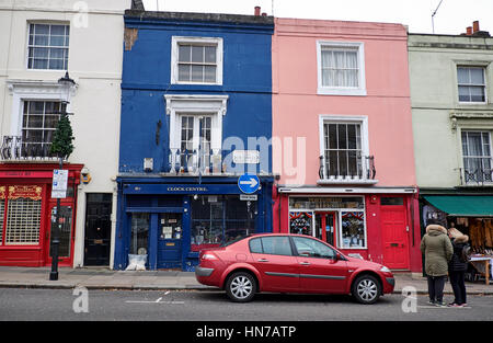 LONDON CITY - 25. Dezember 2016: Auto geparkt und Menschen stehen vor den berühmten farbigen Häusern in Portobello Road in Nottinghill Stockfoto