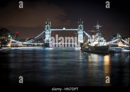 Die Tower Bridge und der HMS Belfast Auf der Themse, London, in der Nacht. Stockfoto