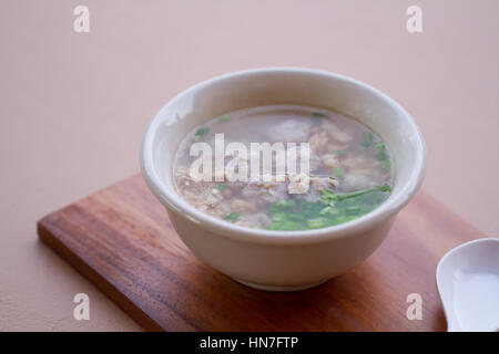 Reis gekocht mit Schweinefleisch, Knoblauch und Koriander Schüssel auf Holz und Löffel. Stockfoto