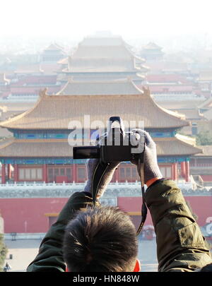 Peking, China. 8. Februar 2017. Ein Mann nimmt Fotos des Palastmuseums im Jingshan-Park in Peking, Hauptstadt von China, 8. Februar 2017. Beijing verstärkt den Schutz der Kulturdenkmäler in den letzten Jahren zur Verbesserung der Umwelt für Menschen wohnen und Verkehr. Bildnachweis: Li Xin/Xinhua/Alamy Live-Nachrichten Stockfoto