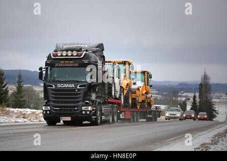 SALO, Finnland - 5. Februar 2017: Schwarz Scania R520 Sattelauflieger von Kuljetus J. Johansson beginnt der Straßentransport von Baustellen-Ausrüstung über Fink Stockfoto