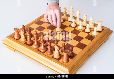 Der Anfang des Spiels - macht die Hand mit dem Bauern den ersten Schritt auf die Chess Board Stockfoto